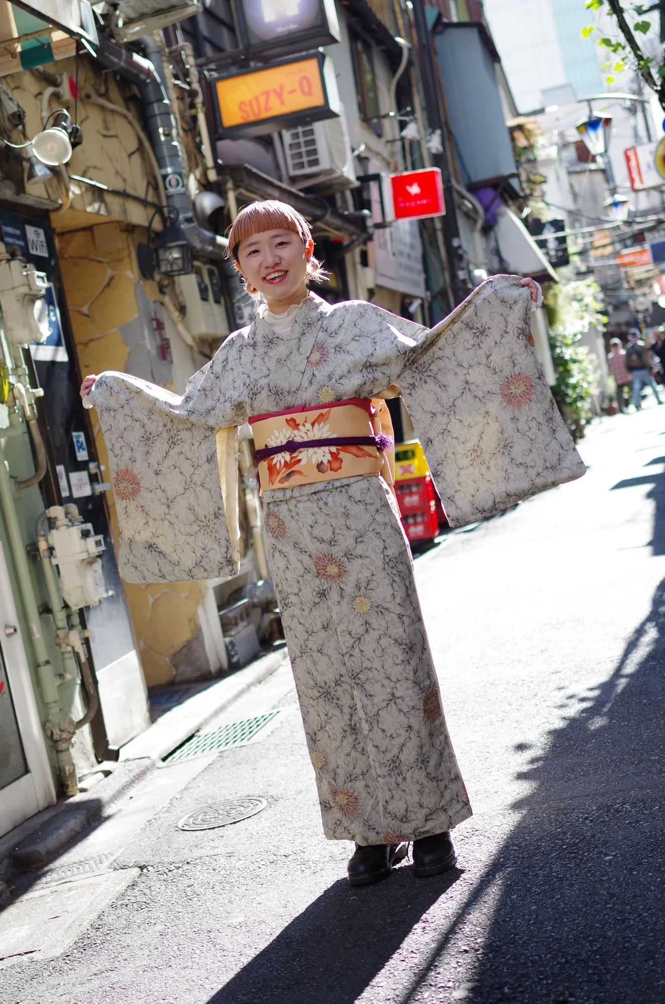 両袖を広げて花柄の着物を見せる人