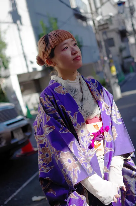 紫地に花柄の着物を着た人