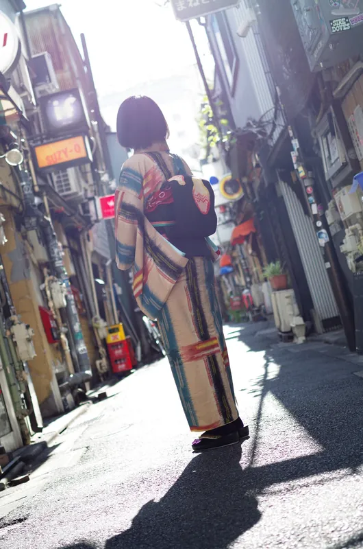 路地を歩くレトロ柄着物の後ろ姿
