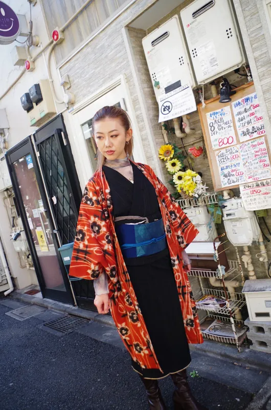 赤い花柄の羽織と黒い着物のコーディネート
