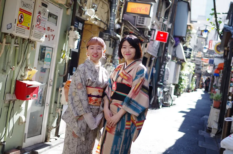 まねき通りに並ぶ花柄小紋とレトロ柄着物の2人